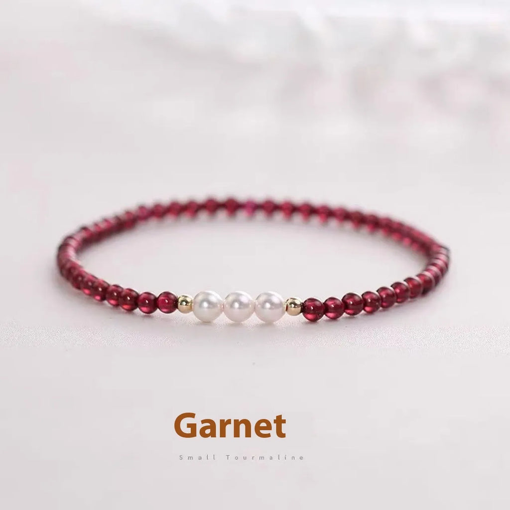 Adjustable women's bracelet with garnet and artificial pearl beads on wrist
