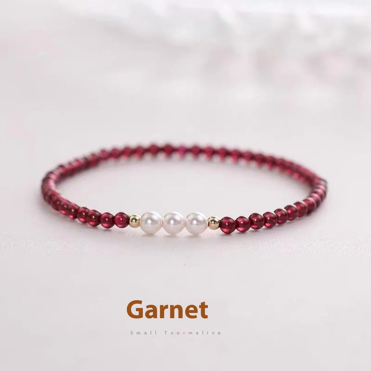 Adjustable women's bracelet with garnet and artificial pearl beads on wrist