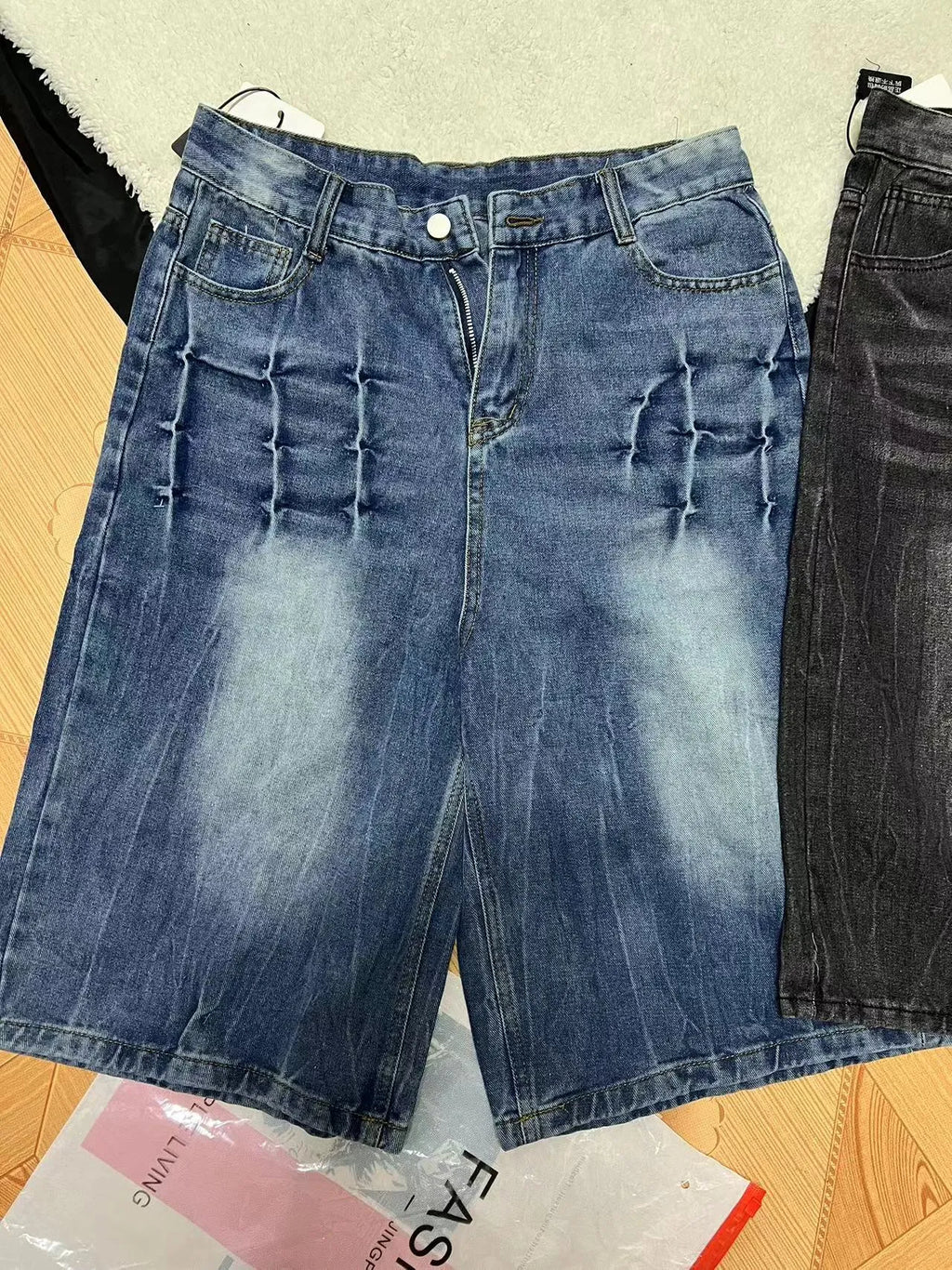 Man wearing loose-fit light blue washed denim shorts with a straight leg and cropped length.
