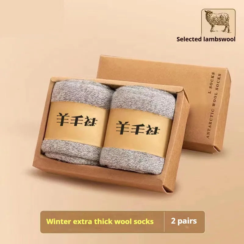 Pair of thick grey wool socks with a reinforced midsole, folded next to their storage box.