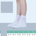 White high-top PVC reusable shoe covers for women, shown on feet.
