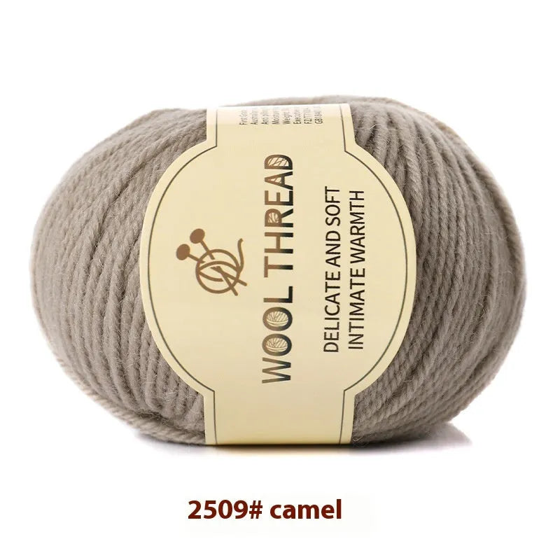 One roll of beige domestic wool hand-knitting yarn for size 10 needles next to knitting needles.