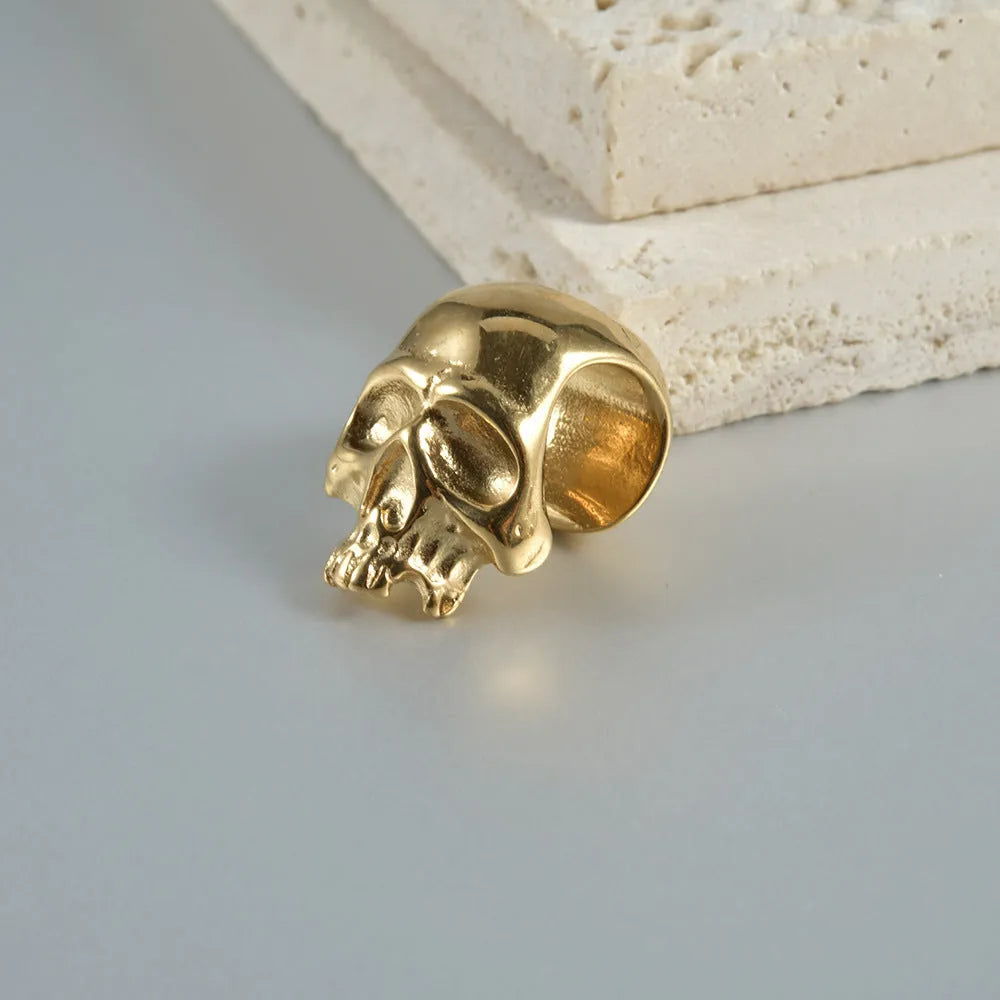 Close-up of personalised stainless steel hollow skull Buddha earrings in hip-hop style.