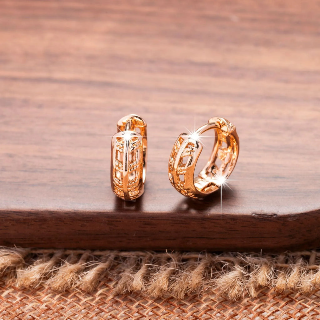 Close-up of rose gold hollowed-out heart and leaf drop earrings showing intricate open metalwork and 2.8cm length.