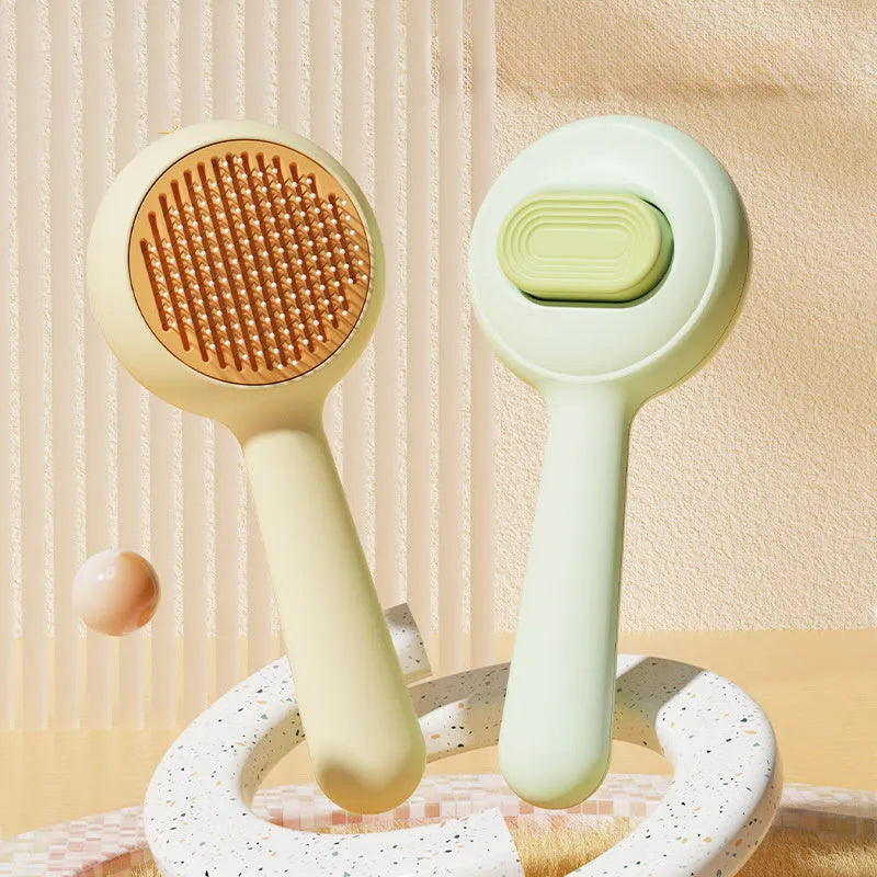 Green and yellow pet grooming brush with stainless steel teeth and a non-slip handle.