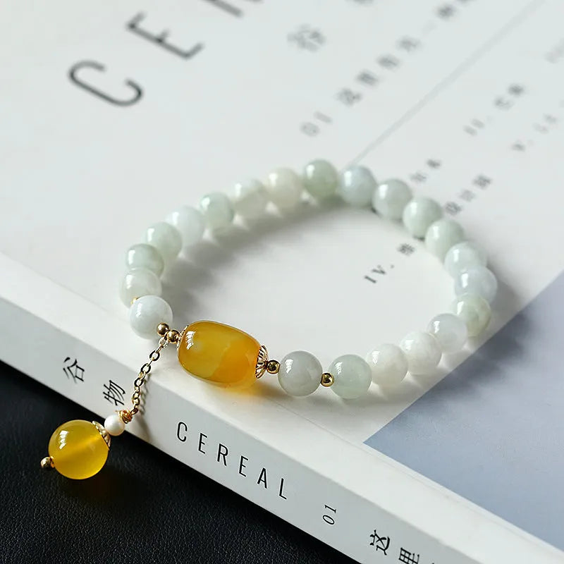 Women's ethnic bracelet with hanging red agate tassel on a gold chain.