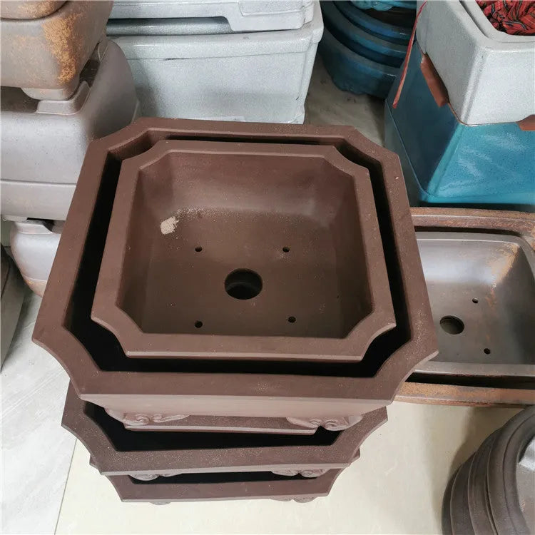 Set of two square stump purple sand flowerpots in brown finish on a flat surface