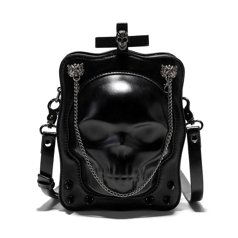 Black mini square crossbody bag with embossed skull design, metal chain strap, and zip closure.