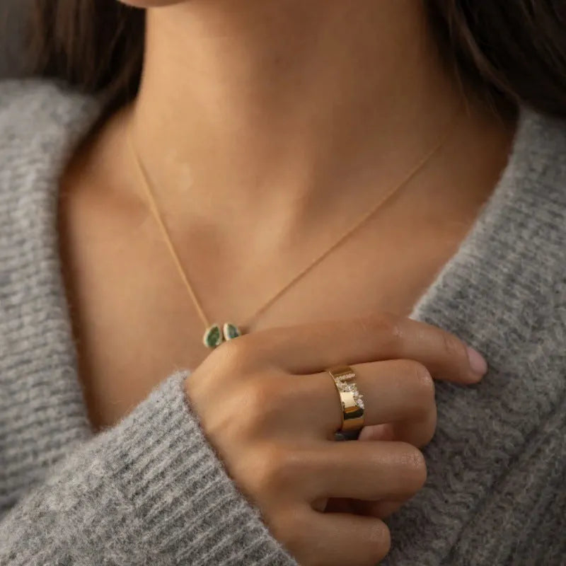 Gold electroplated copper ring for women with shining zircon details, shown on a finger.