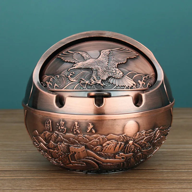 Bronze and red copper alloy decorative ashtray with smoke-extinguishing slot on a table.