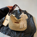 Women's straw woven messenger bag with hollowed design in khaki colour, showing vertical square shape and shoulder strap