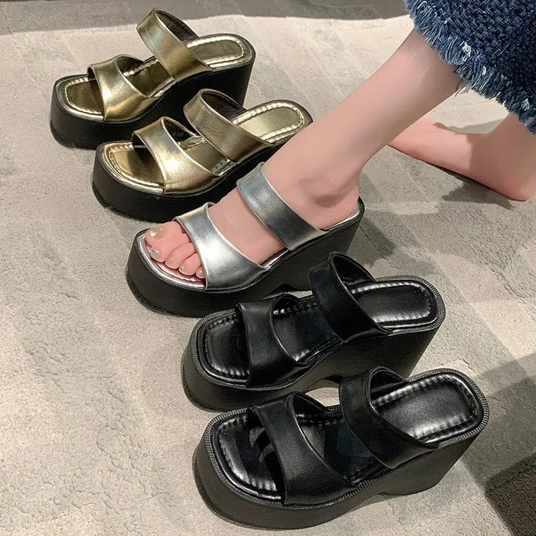 Women's black wedge platform slippers with square toe on a white background.