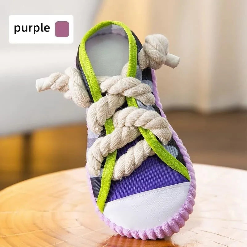 Grey and white dog toy slipper with black laces, blue sole, and a bell on the side