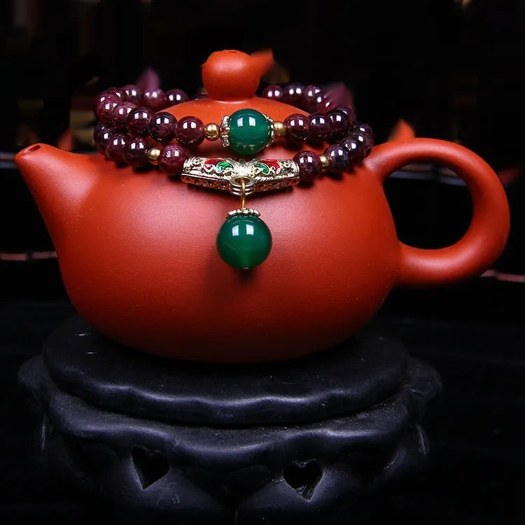 Natural garnet bracelet with 7mm beads and double-ring clasp for women, showing ordinary and upgraded quality options