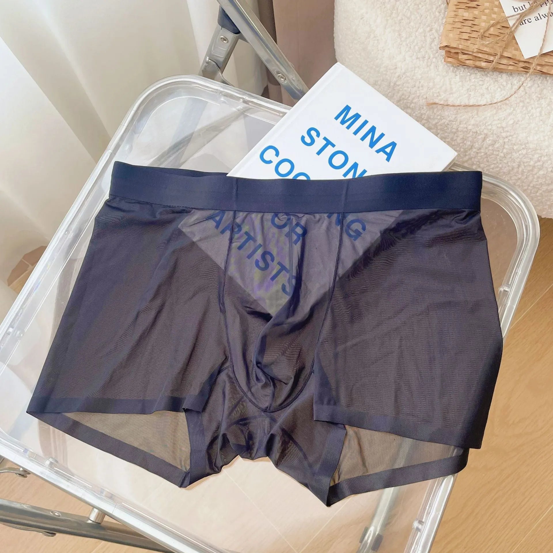 Man wearing thin grey seamless nylon boxer shorts with a mid-waist design.