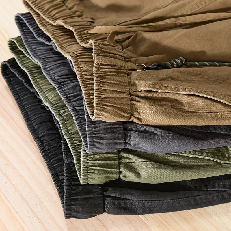 Men's army green cotton drawstring overalls with ankle bands laid flat.