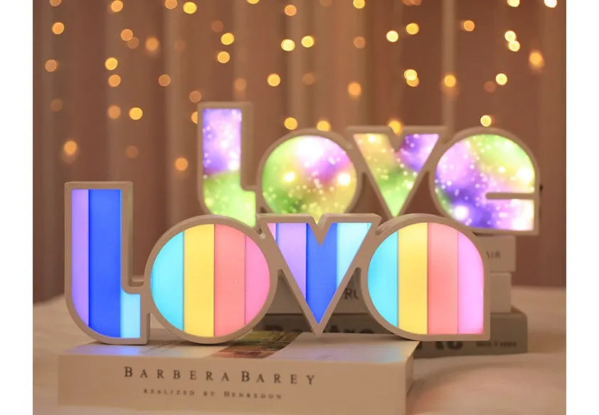 Rainbow colour LED LOVE light decoration for Valentine's Day or weddings on a desk.