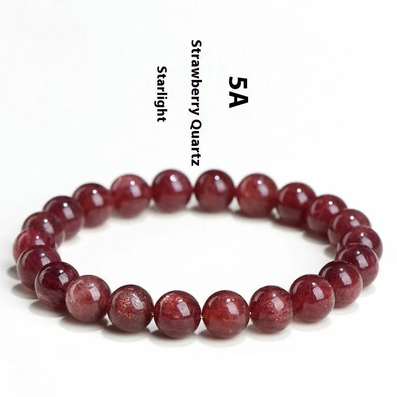 Cherry red strawberry quartz crystal bracelet with geometric beads on a wrist.