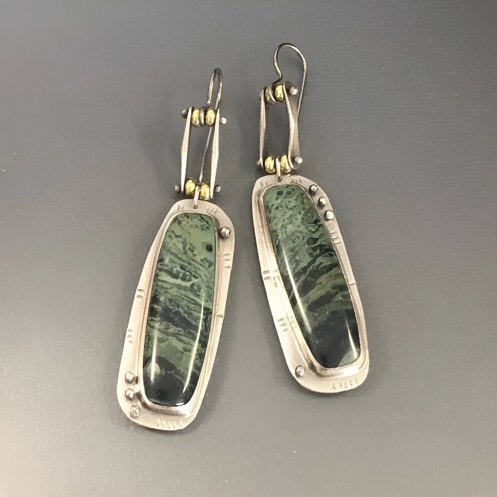 A pair of geometric-shaped alloy earrings with a white and grey marble pattern.