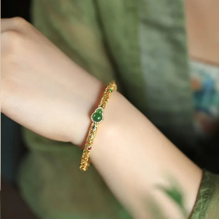 Gold-toned open design gourd charm bracelet with a dark adjustable silk cord for women.