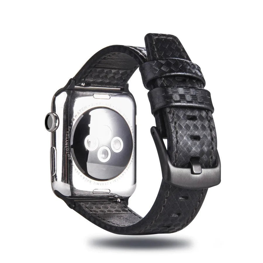 Leather and carbon fibre Apple Watch strap with red stitching next to a black PC case with carbon fibre pattern.