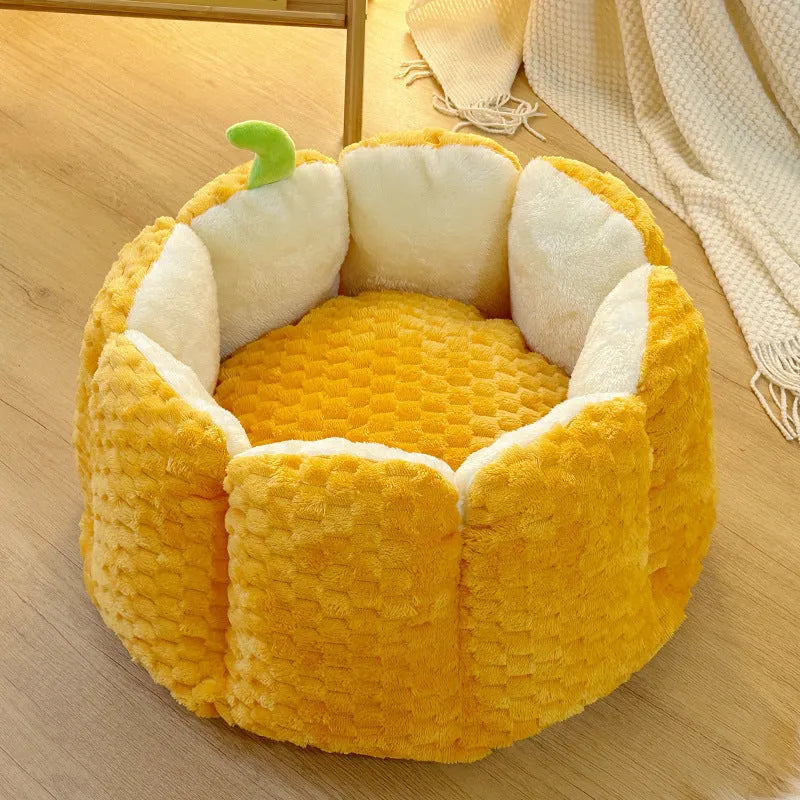 Orange pumpkin-shaped pet bed nest for cats and small dogs on a wooden floor.