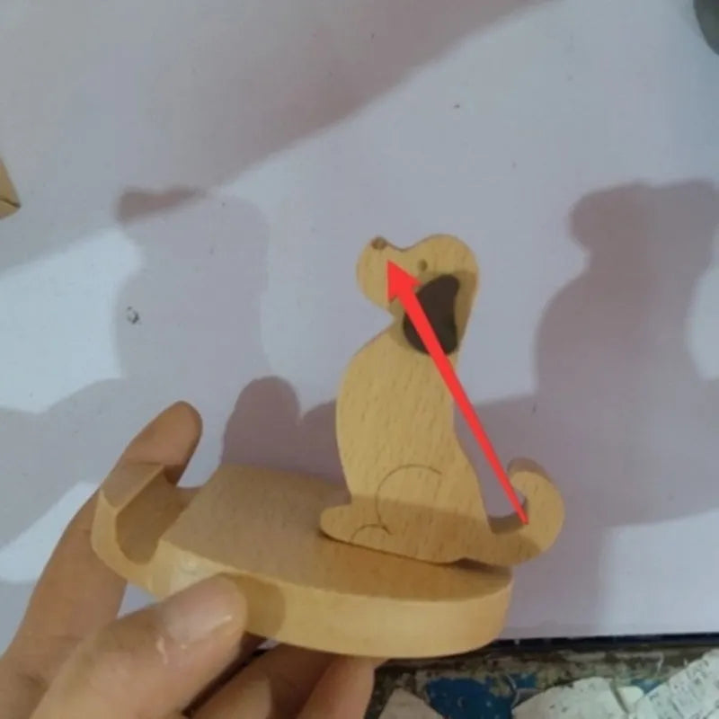 Sculpted beech wood lazy bracket phone holder with custom engraved text on a wooden desk.