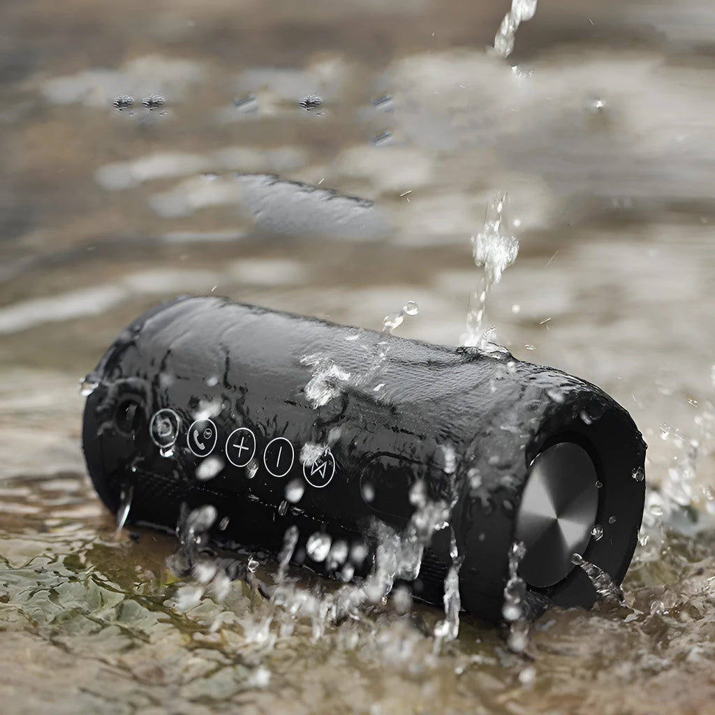Compact waterproof Bluetooth speaker in camouflage colour, shown outdoors on a rock.