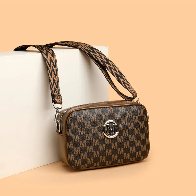 Soft PU crossbody shoulder bag in black with a wide strap and a three-dimensional front pocket.