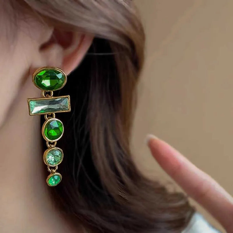 Green gradient geometric alloy earrings with a long tassel and sparkling inlaid zircon centre on a white background.