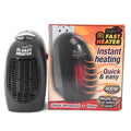 Black compact ceramic electric heater with digital display and rotating plug on a desk.