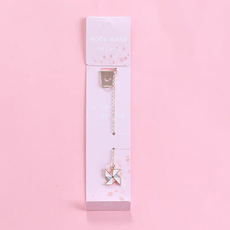 Cartoon-themed alloy metal bookmark charm on a book page.