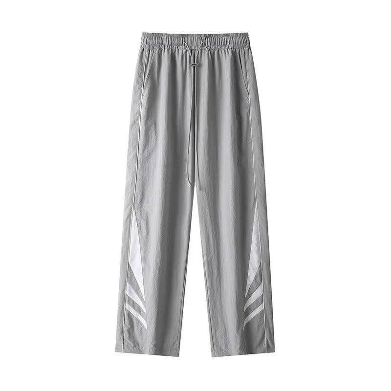A man wearing black straight-leg loose-fit casual sports trousers for summer.