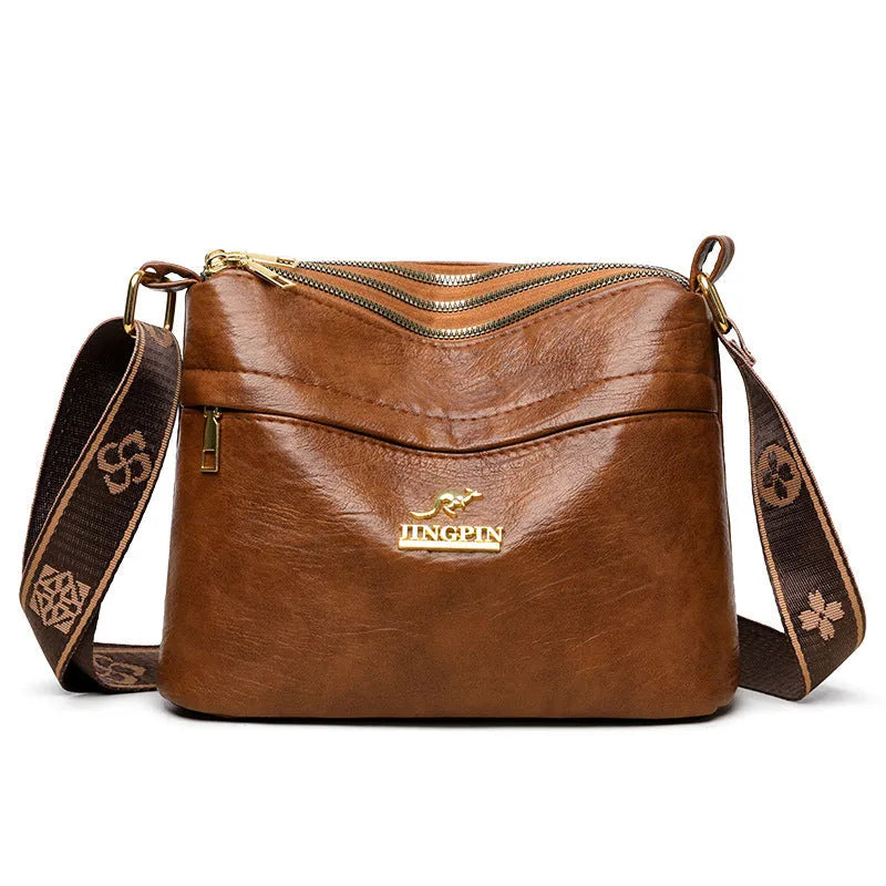 Brown cross body messenger bag with multiple compartments and sewing thread details on PU material