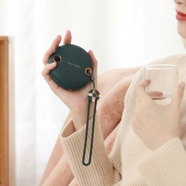 Green 5000mAh power bank hand warmer with digital display shown next to its charging cable.