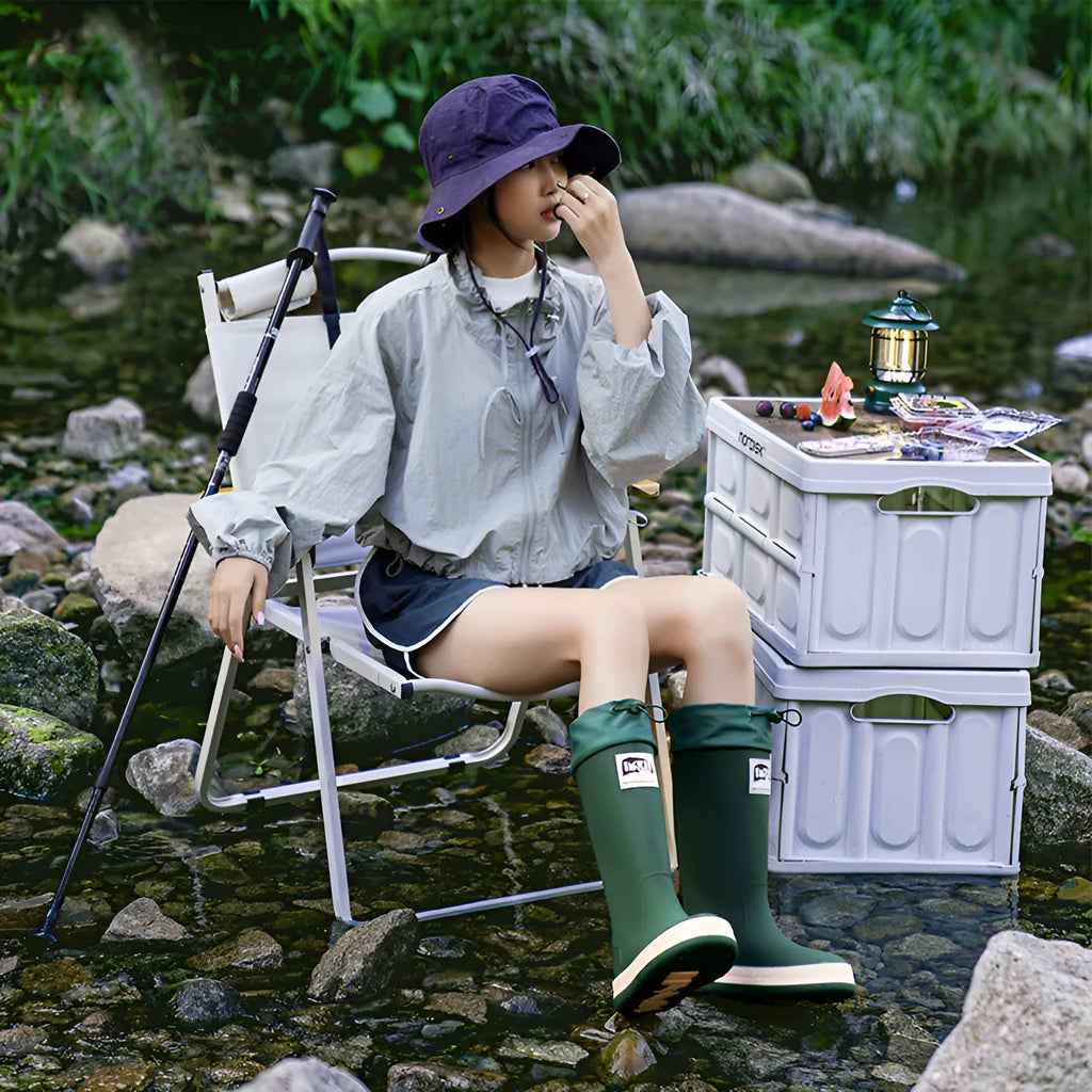 A pair of high tube PVC rain boots in a solid colour, shown on a size label with a non-slip sole.