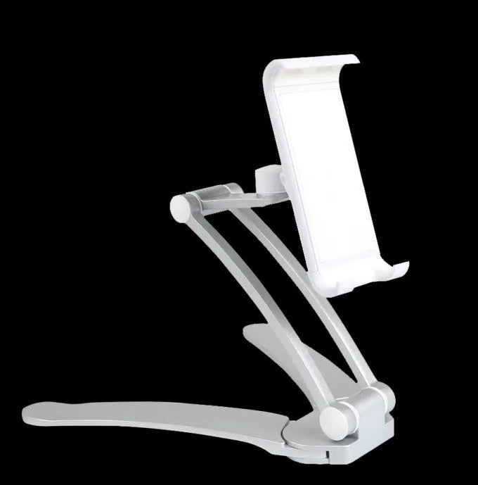Silver aluminium alloy tablet stand with adjustable black clips holding a tablet, showing 360-degree rotation on a wooden desk.