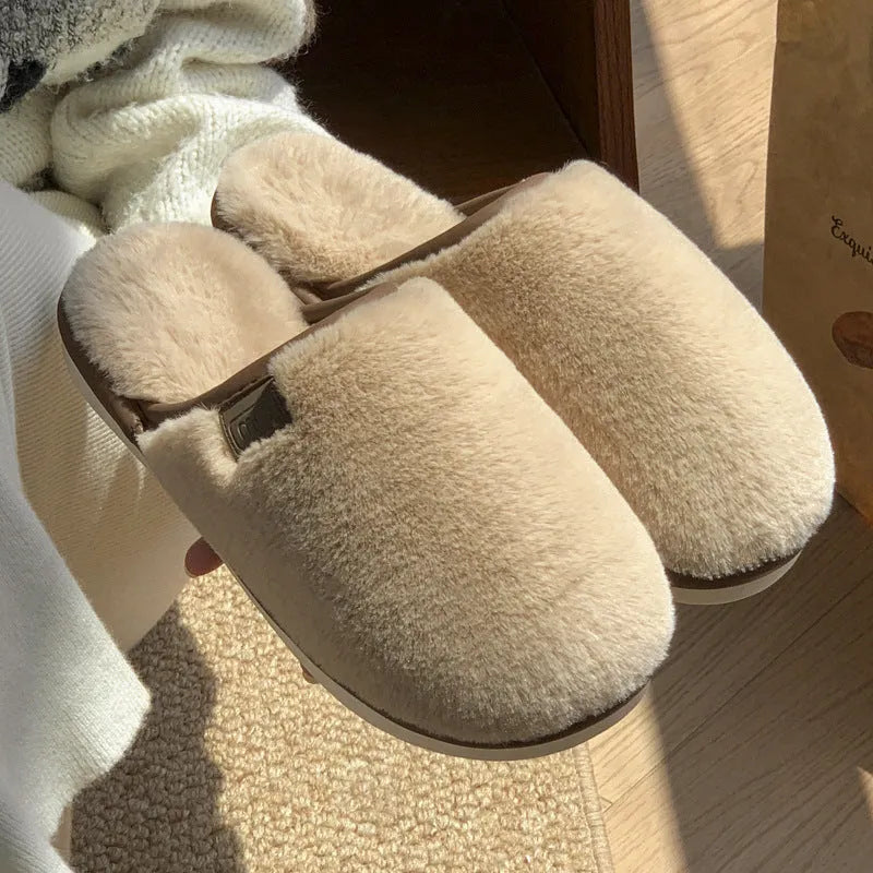 Pair of solid-colour plush winter slippers with a slip-on design and a textured PVC sole.