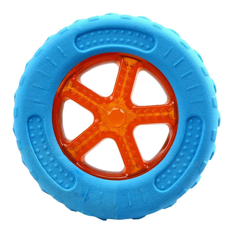 Set of four squeaky dog toys: a blue ball, a red barbell, and two orange tyres, shown on grass.