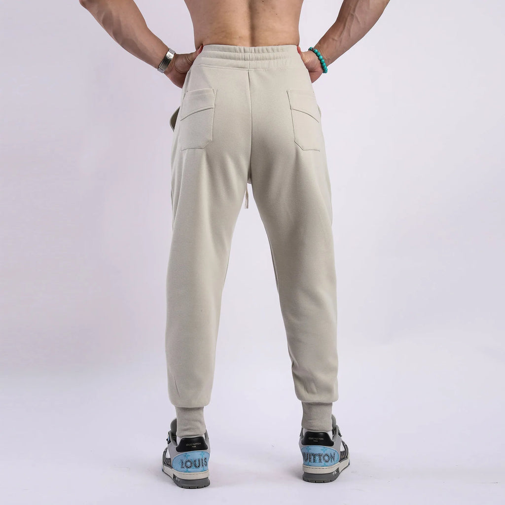 Man wearing grey ankle-tie drawstring sweatpants for casual leisure.