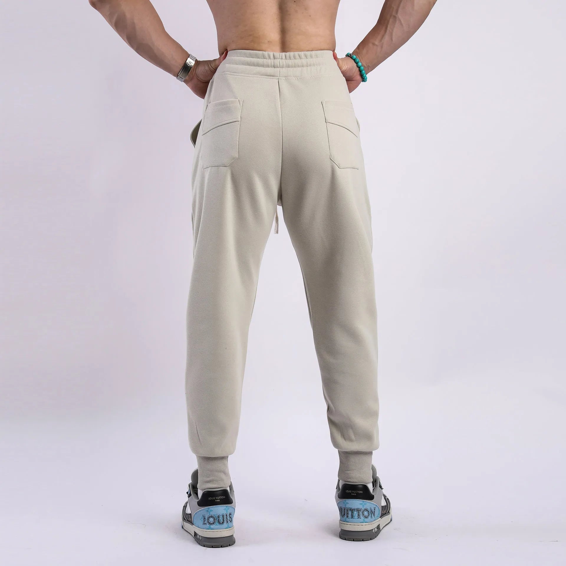 Man wearing grey ankle-tie drawstring sweatpants for casual leisure.