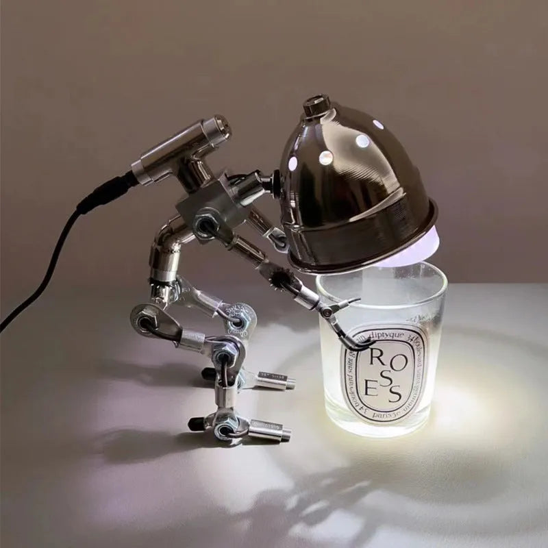 Silver copper robot-shaped decorative mood lamp on a desk.