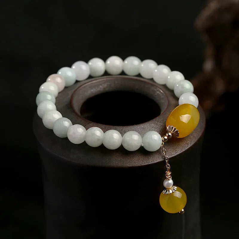 Women's ethnic bracelet with hanging red agate tassel on a gold chain.