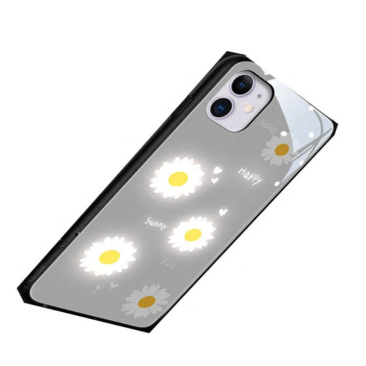 White luminous iPhone case with painted daisies and voice-activated colour-changing LED lights on a smartphone.