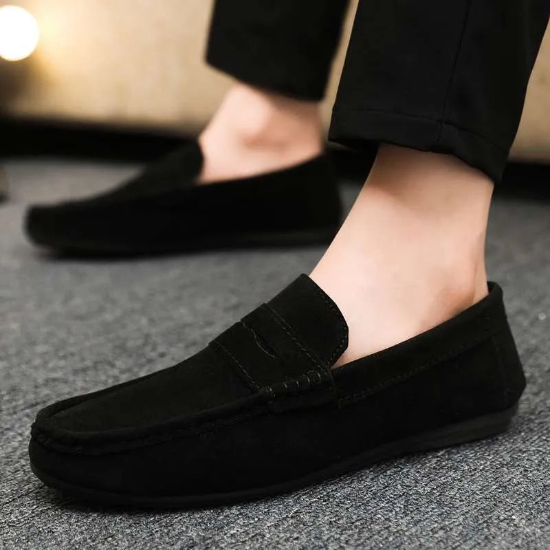 Men's black slip-on shoes with round toe, grape particle detail, and rubber sole.