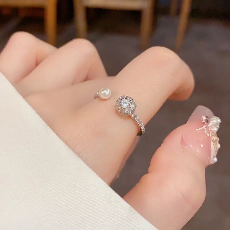 Golden open-end ring with round zircon stone on a white background.