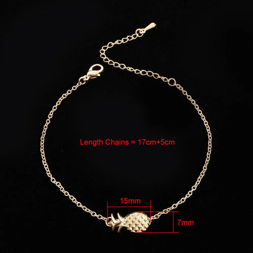 Gold and silver alloy pineapple charm bracelet on wrist, showing adjustable clasp.