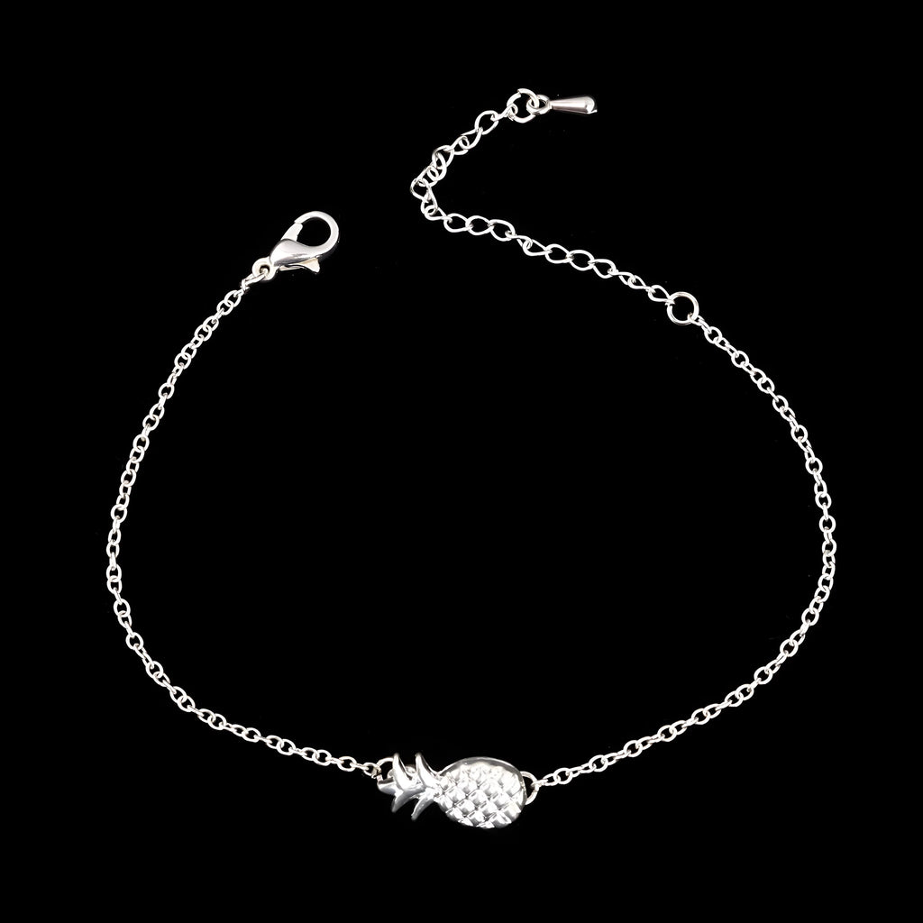 Gold and silver alloy pineapple charm bracelet on wrist, showing adjustable clasp.