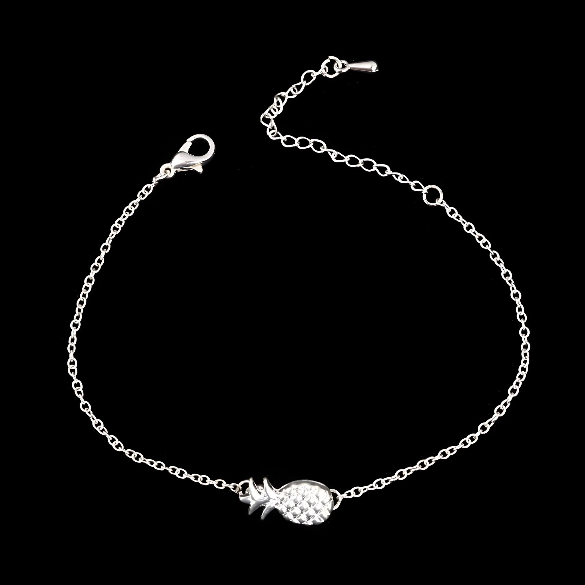 Gold and silver alloy pineapple charm bracelet on wrist, showing adjustable clasp.