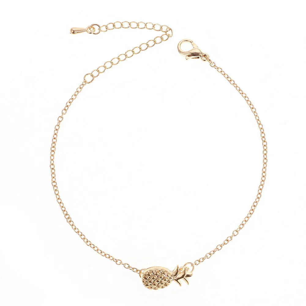 Gold and silver alloy pineapple charm bracelet on wrist, showing adjustable clasp.